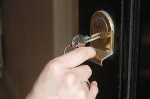 A closeup of someone unlocking a deadbolt.