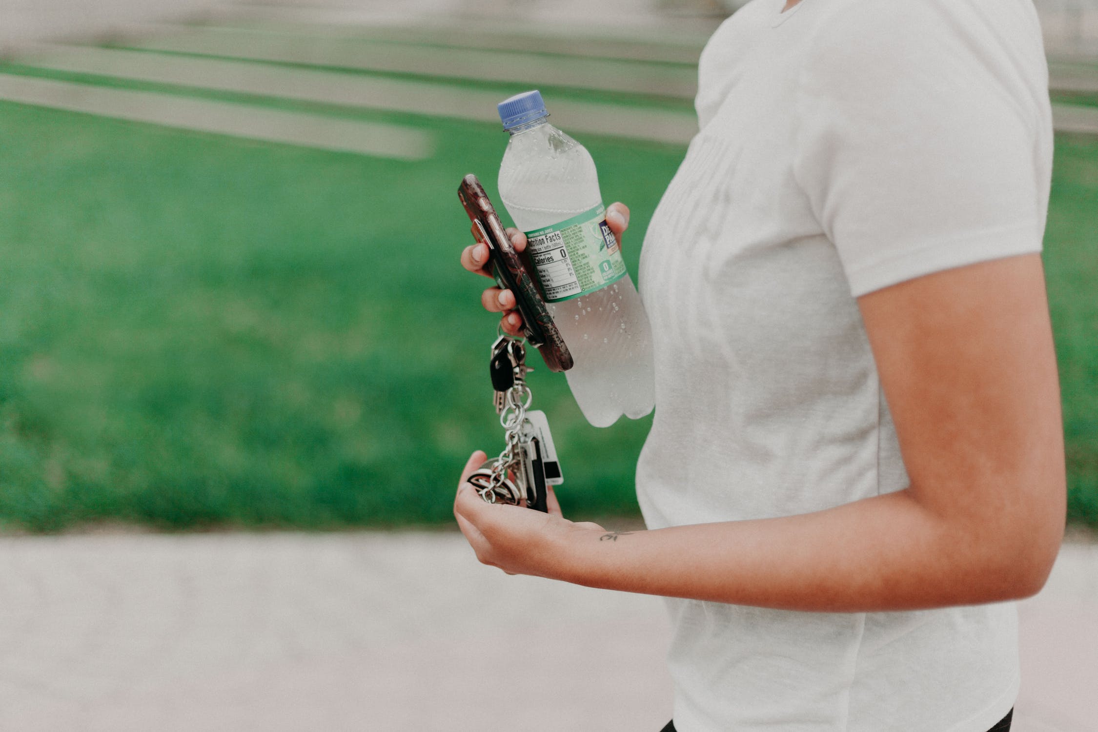 holding keys and water bottle outside